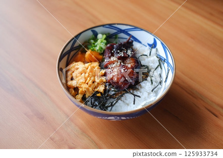 a beautifully arranged Japanese rice bowl served in a traditional patterned ceramic bowl a beautifully arranged Japanese rice bowl served in a traditional patterned ceramic bowl 125933734
