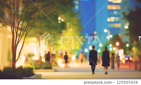 Men and women walking home in an office district at night 125935429