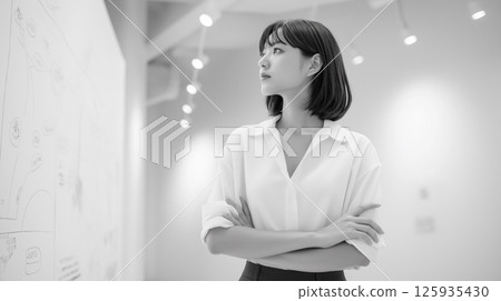 A young female leader is thinking and looking at the wall during a meeting in the office 125935430