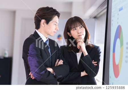 Young men and women in suits struggling with the content of their presentation 125935886