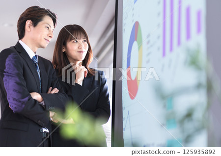 Young men and women in suits struggling with the content of their presentation 125935892