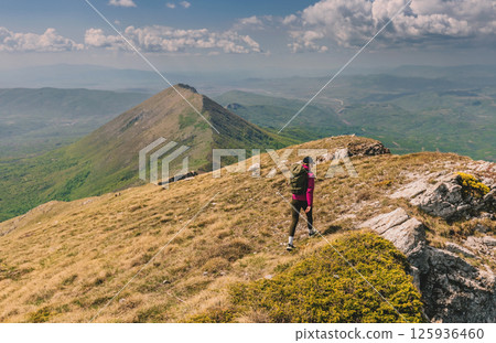 Woman Traveling with Backpack Hiking Alone in Mountains Woman Traveling with Backpack Hiking Alone in Mountains 125936460
