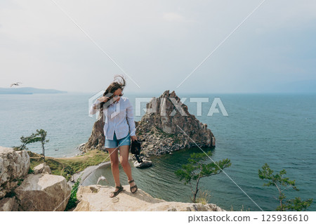Woman stand on view point of Shamanka rock at Olhon Island in Baikal lake 125936610