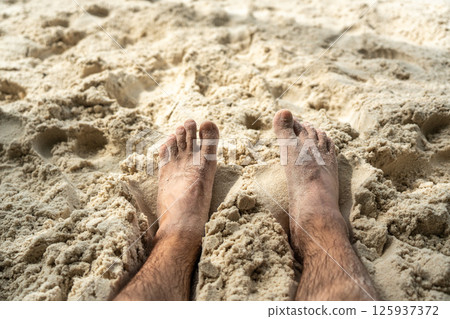 Bare feet resting in warm sand on tropical beach, symbolizing summer relaxation, freedom Bare feet resting in warm sand on tropical beach, symbolizing summer relaxation, freedom 125937372