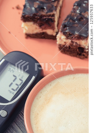 Glucometer for measuring sugar level, cheesecake with cherries Glucometer for measuring sugar level, cheesecake with cherries 125937633