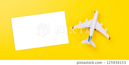 Travel-themed flat lay with blank photo card and toy airplane 125938153