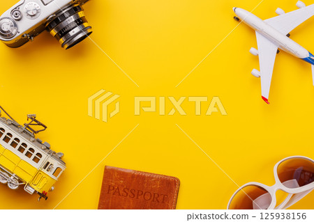 Travel-themed flat lay with toy airplane, camera, and sunglasses Travel-themed flat lay with toy airplane, camera, and sunglasses 125938156