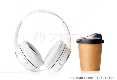A paper coffee cup paired with headphones placed on a clean white background 125938182