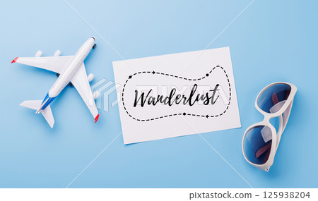 Travel-themed flat lay with card, sunglasses and toy airplane 125938204