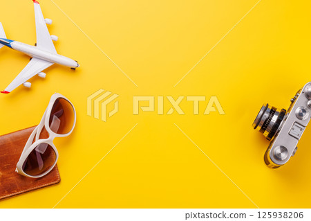 Travel-themed flat lay with toy airplane, camera, and sunglasses Travel-themed flat lay with toy airplane, camera, and sunglasses 125938206