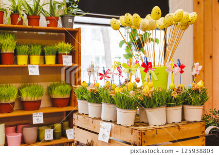 Easter decorations with wheatgrass and colorful eggs on display in flower shop 125938803