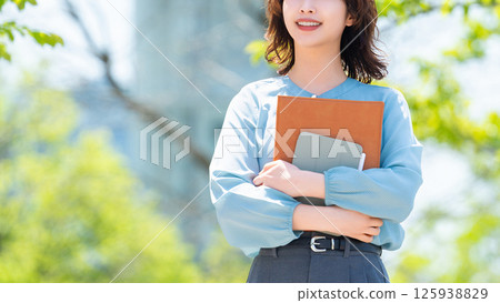 Smiling woman/businesswoman walking outdoors 125938829