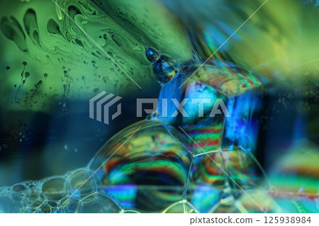 Green and blue liquid surface, green Reflections of liquid in macro,, bubbles in macro, connection of bubbles in macro, cell from liquid, dark background, glossy surface Green and blue liquid surface, green Reflections of liquid in macro,, bubbles in macro, connection of bubbles in macro, cell from liquid, dark background, glossy surface 125938984