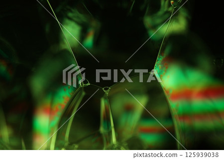 Green liquid surface on dark background, green Reflections of liquid in macro, green liquid surface, bubbles in macro, connection of bubbles in macro, cell from liquid, dark background, glossy surface 125939038