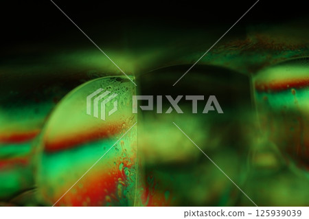 Green liquid surface on dark background, green Reflections of liquid in macro, green liquid surface, bubbles in macro, connection of bubbles in macro, cell from liquid, dark background, glossy surface Green liquid surface on dark background, green Reflections of liquid in macro, green liquid surface, bubbles in macro, connection of bubbles in macro, cell from liquid, dark background, glossy surface 125939039