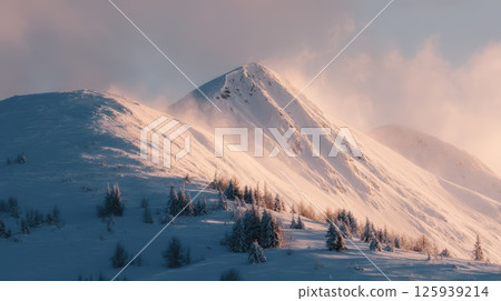 Snow-Covered Mountain Peaks at Sunrise with Dramatic Clouds 125939214
