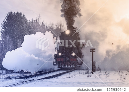 Retro steam train arrives at winter morning. 125939642