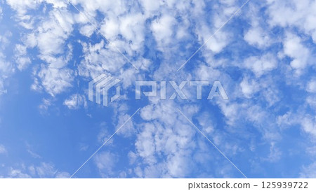 Camera move behind white fluffy clouds on blue sky at summer sunny day. Beautiful nature background. Close up Slow motion 125939722