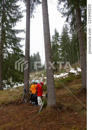 Explorers navigate the snowy forest landscape as solitude invites adventure and discovery in a serene winter wonderland setting 125940920