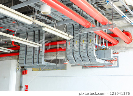 electrical steel pipeline, Electrical cable wire way on wall, cable routing between electrical distribution panel with equipment, industry construction concept background. electrical steel pipeline, Electrical cable wire way on wall, cable routing between electrical distribution panel with equipment, industry construction concept background. 125941376