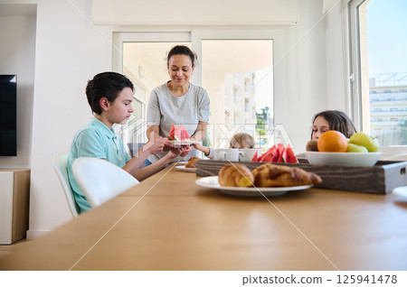 Happy Family Enjoying Breakfast Together on a Bright Sunny Morning Happy Family Enjoying Breakfast Together on a Bright Sunny Morning 125941478