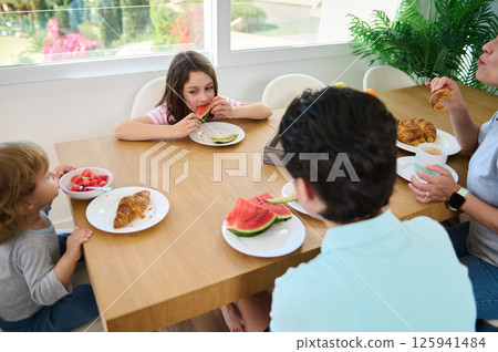 Family Enjoying Breakfast Together in a Bright and Modern Setting Family Enjoying Breakfast Together in a Bright and Modern Setting 125941484