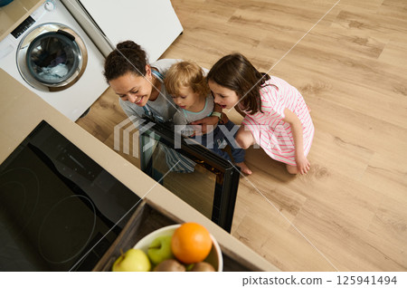 Happy Family Bonding Over Baking in Light and Modern Kitchen Setting 125941494
