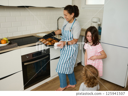 Mother Baking Homemade Croissants with Children in Modern Kitchen Setting Mother Baking Homemade Croissants with Children in Modern Kitchen Setting 125941507