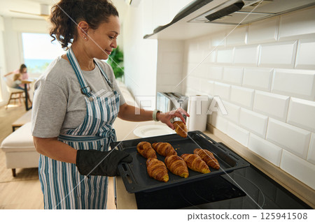 Mother Baking Homemade Croissants in a Bright and Modern Kitchen 125941508