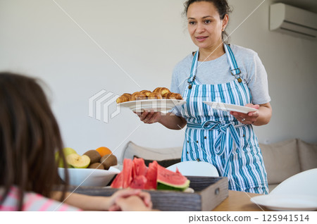 Mother Preparing Croissants for Family Breakfast at Home Mother Preparing Croissants for Family Breakfast at Home 125941514