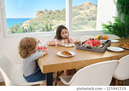 Family Enjoying Breakfast with Fresh Fruits and Pastry at Home Family Enjoying Breakfast with Fresh Fruits and Pastry at Home 125941519