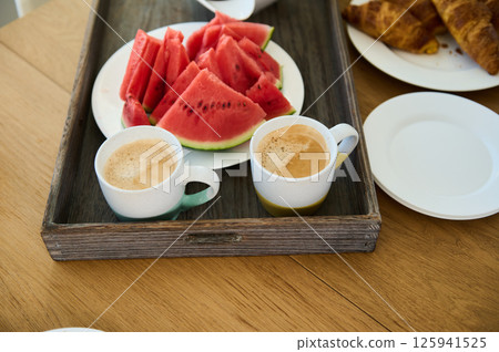 Healthy Breakfast Spread with Fresh Watermelon, Coffee, and Croissants Healthy Breakfast Spread with Fresh Watermelon, Coffee, and Croissants 125941525