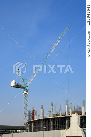 construction tower crane work with construction worker on top of building, used in construction site with blue sky. construction tower crane work with construction worker on top of building, used in construction site with blue sky. 125941641