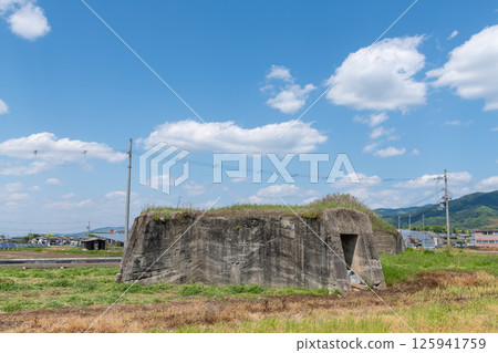 The remains of the northern air raid shelter of the former Japanese military's Yanagimoto Airfield, standing in a rice paddy area before rice planting The remains of the northern air raid shelter of the former Japanese military's Yanagimoto Airfield, standing in a rice paddy area before rice planting 125941759