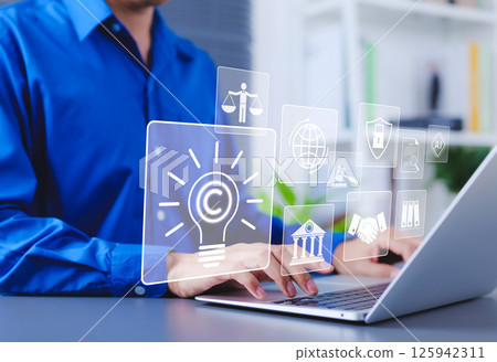 Copyright and intellectual property protection concept. Man using laptop with digital icons representing copyright, intellectual property, legal protection, innovation rights, and data security. 125942311