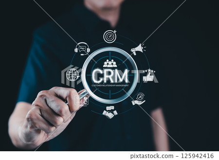 CRM System for Customer Relationship Management. A person interacts with CRM interface icons for support, analytics, marketing, and feedback, illustrating customer relationship management in business. 125942416