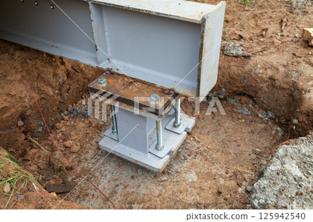 Concrete foundations support metal columns Concrete foundations support metal columns 125942540