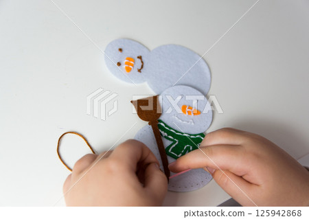 The hand of the child make snowman for christmas greeting card. Hobby concept. Handmade. The hand of the child make snowman for christmas greeting card. Hobby concept. Handmade. 125942868