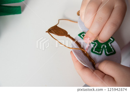 The hand of the child make snowman and christmas tree with needle, thread for christmas greeting card. Hobby concept. Handmade. 125942874