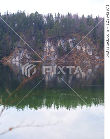 Mountain reflections on a calm lake in autumn during overcast weather 125942971
