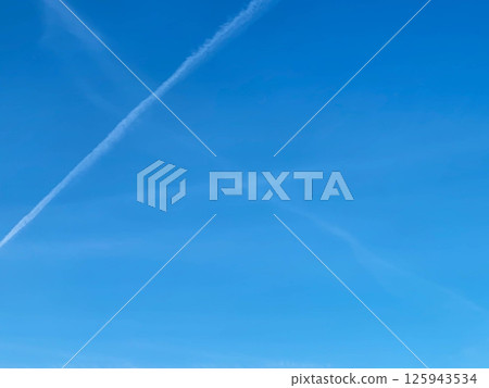 Airplane tracks in the clear blue sky on a bright sunny day Airplane tracks in the clear blue sky on a bright sunny day 125943534