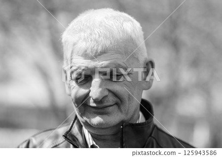 A well-dressed elderly man is smiling. A gray-haired man stands on the street. A well-dressed elderly man is smiling. A gray-haired man stands on the street. 125943586