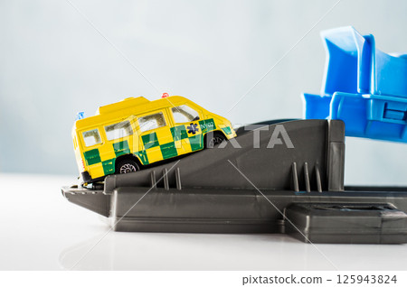 Plastic track with a yellow ambulance. 125943824