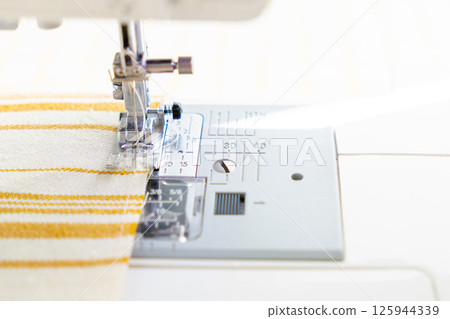 sewing machine with a cloth under a steel needle. manufacture of clothing. sewing machine with a cloth under a steel needle. manufacture of clothing. 125944339