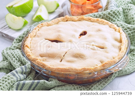 Freshly baked sweet potato and apple cobbler in glass baking dish, horizontal 125944739
