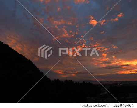 At dusk, the clouds above Lake Inawashiro glow like orange neon lights in the afterglow, creating an impressive and beautiful sight against the dark blue sky. At dusk, the clouds above Lake Inawashiro glow like orange neon lights in the afterglow, creating an impressive and beautiful sight against the dark blue sky. 125946464