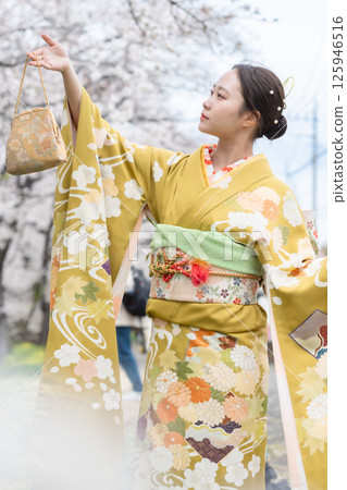 身著和服、櫻花盛開的成年女性 125946516