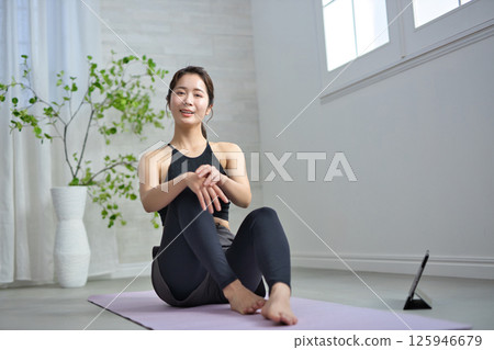 A woman in her twenties enjoying online yoga A woman in her twenties enjoying online yoga 125946679