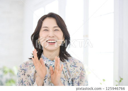 一位身穿花襯衫、微笑的中年婦女 125946766