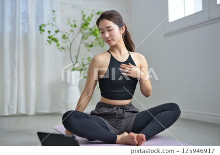 A woman in her twenties enjoying online yoga A woman in her twenties enjoying online yoga 125946917